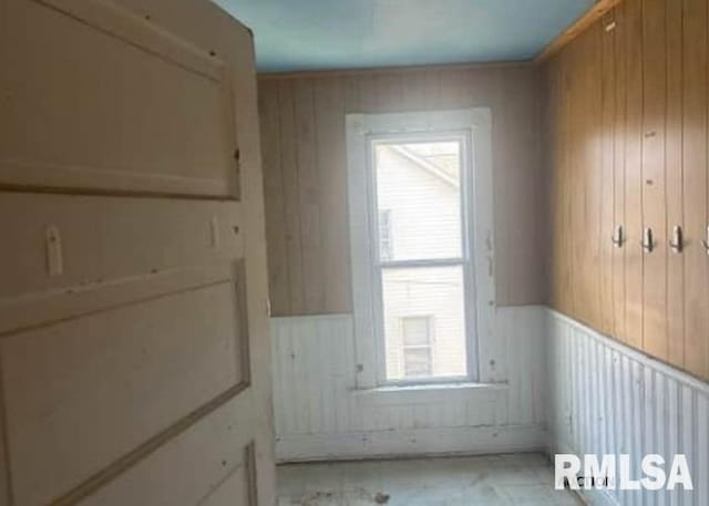 unfurnished room featuring wainscoting