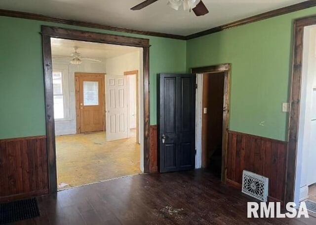 448 N 3rd Ave, Canton, IL 61520 - unfurnished room with a ceiling fan, a wainscoted wall, wood finished floors, ornamental molding, and wooden walls