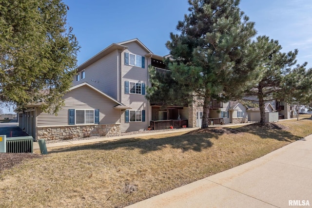 view of front of house with stone siding and a front lawn