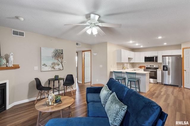 living area featuring light wood finished floors and visible vents