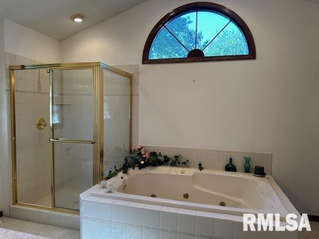 bathroom featuring a tub with jets, a stall shower, and vaulted ceiling