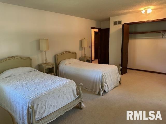 bedroom with carpet, visible vents, and baseboards