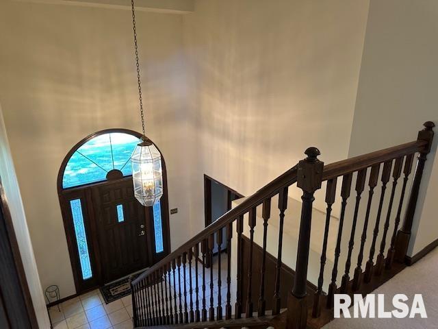 entryway featuring stairway, a high ceiling, and light tile patterned flooring