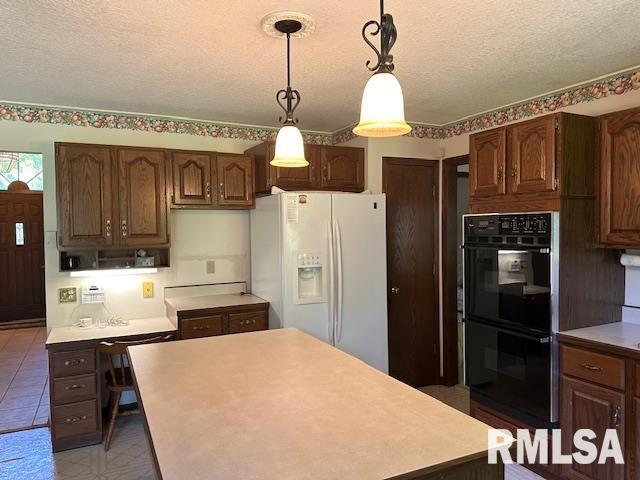 kitchen with a center island, light countertops, white fridge with ice dispenser, a textured ceiling, and dobule oven black