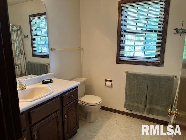 full bath featuring baseboards, toilet, vanity, and a shower with curtain