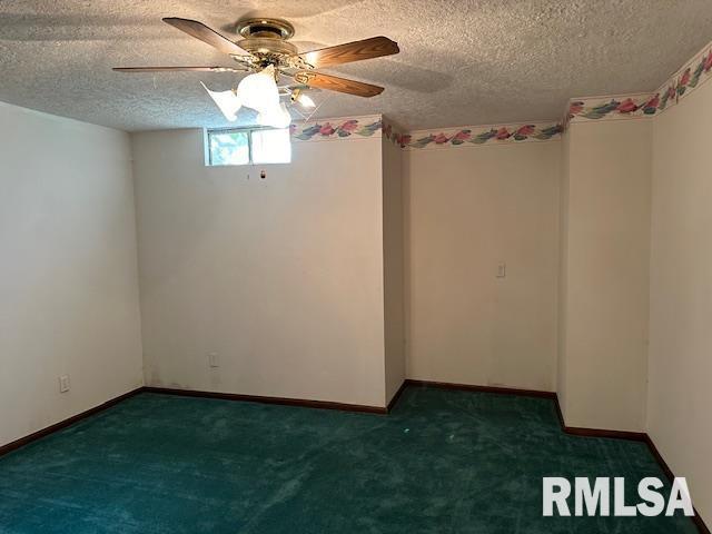 carpeted spare room with ceiling fan, a textured ceiling, and baseboards