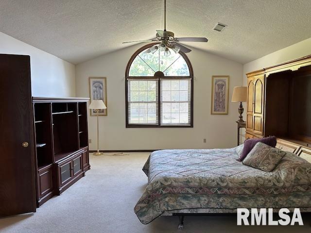 bedroom featuring a textured ceiling, visible vents, light colored carpet, and vaulted ceiling