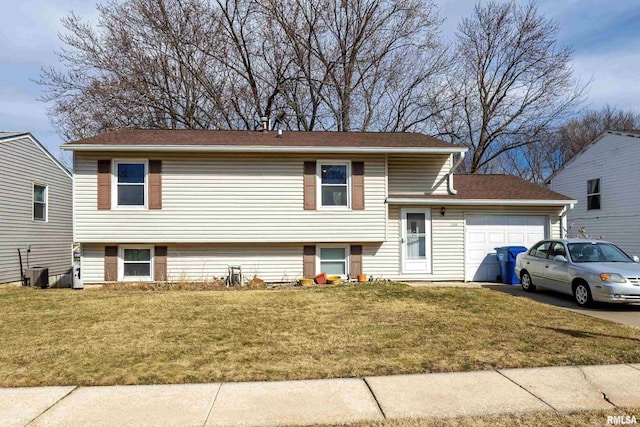 tri-level home featuring central AC unit, an attached garage, driveway, and a front yard