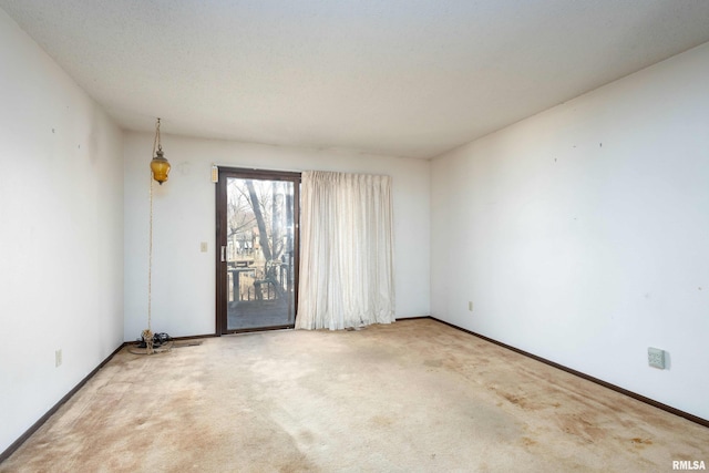 empty room featuring carpet and baseboards