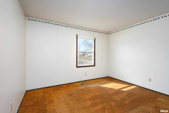 empty room featuring visible vents, baseboards, and carpet