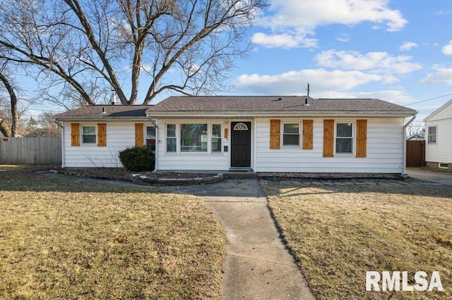 ranch-style house featuring a front lawn and fence