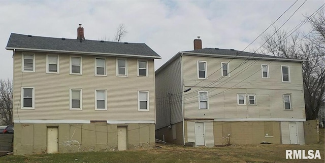 rear view of property featuring a chimney