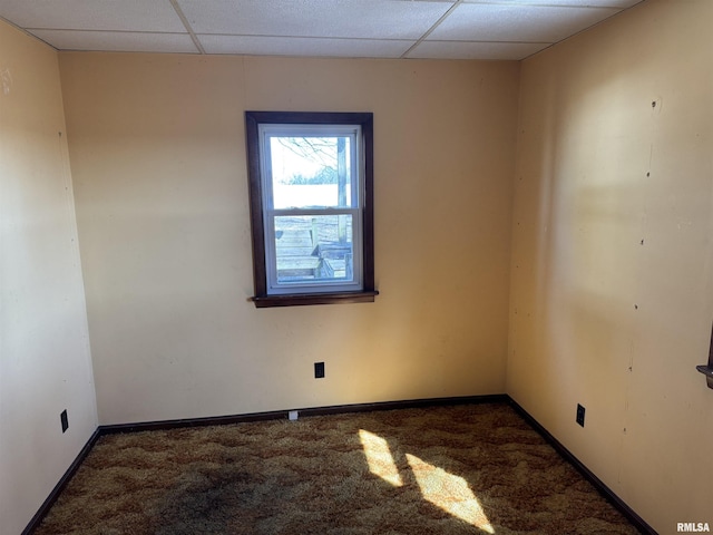 spare room featuring baseboards, a paneled ceiling, and carpet