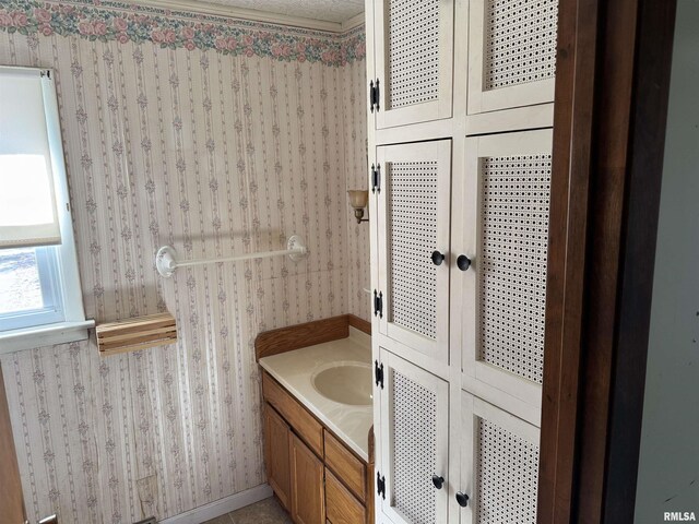 bathroom featuring vanity and wallpapered walls
