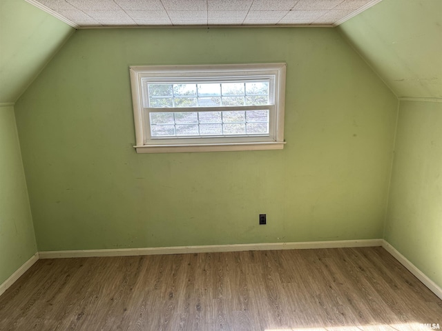 additional living space featuring vaulted ceiling, wood finished floors, and baseboards