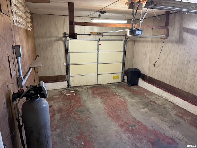 garage with wood walls and a garage door opener