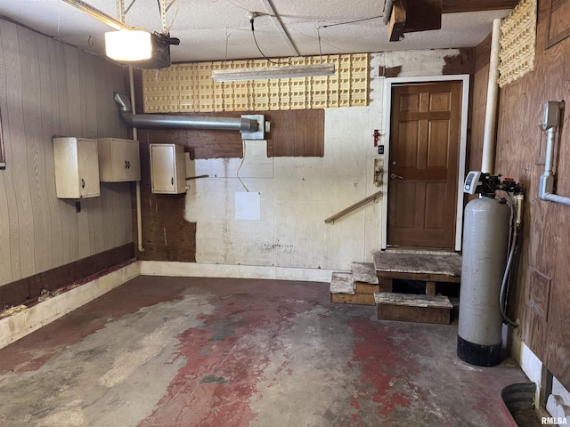 garage featuring wooden walls, electric panel, and a garage door opener