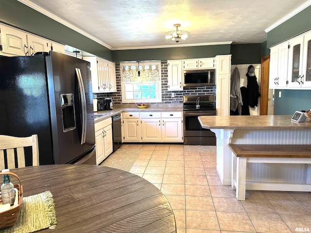 kitchen featuring a chandelier, stainless steel appliances, crown molding, and light tile patterned flooring