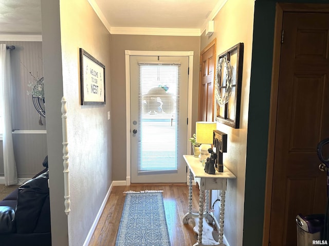 doorway with crown molding, baseboards, and wood finished floors