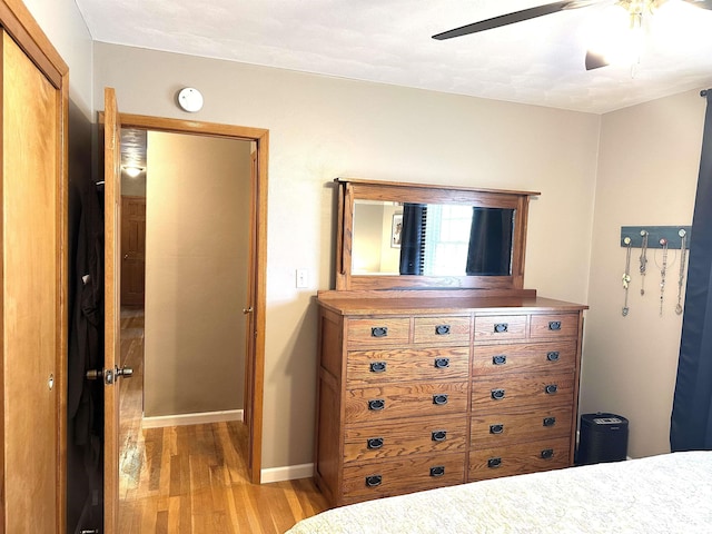 unfurnished bedroom with light wood-style flooring, baseboards, and a ceiling fan