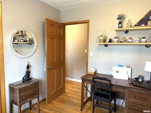 office area featuring baseboards and light wood finished floors