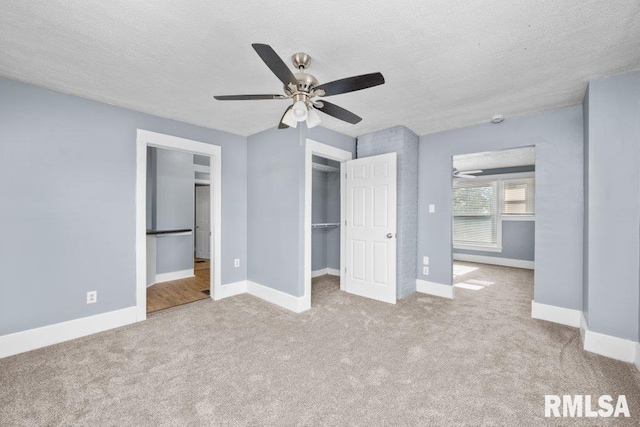 unfurnished bedroom with carpet flooring, baseboards, and a textured ceiling