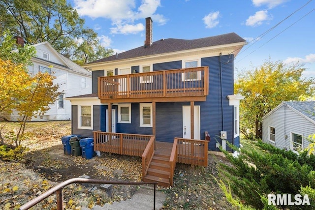 rear view of house with a wooden deck and a chimney