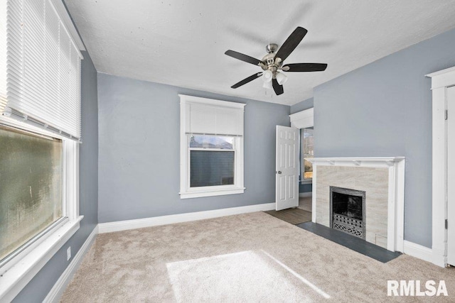 unfurnished living room with a premium fireplace, carpet, and a healthy amount of sunlight