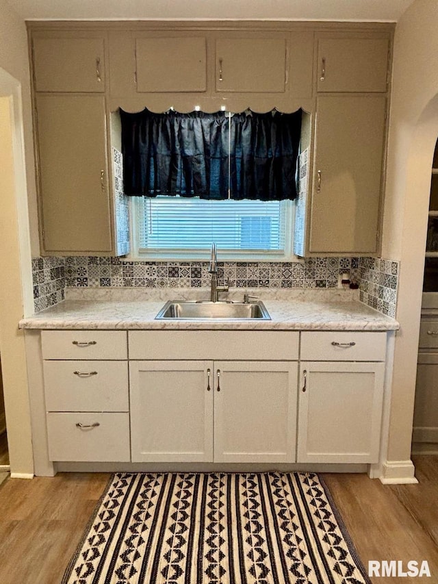 kitchen featuring a sink, tasteful backsplash, and light countertops