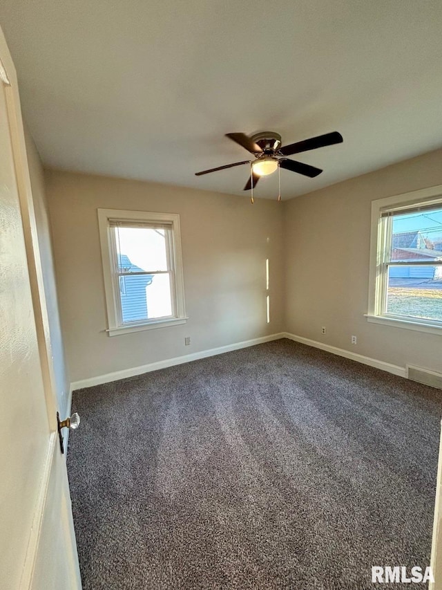 unfurnished room featuring carpet flooring, a ceiling fan, baseboards, and a wealth of natural light