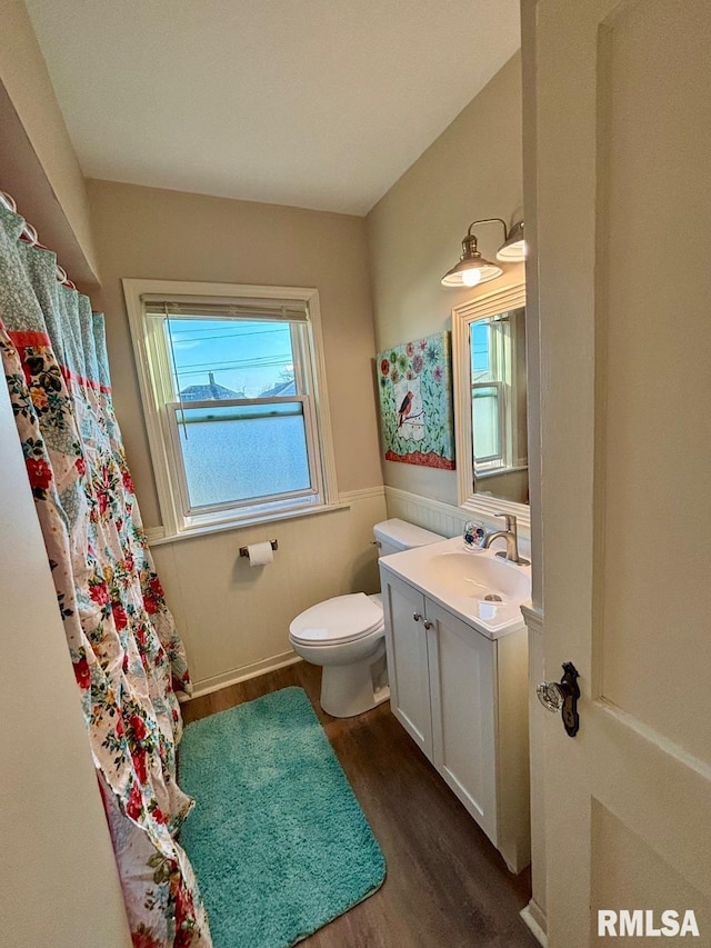 full bathroom with toilet, curtained shower, vanity, and wood finished floors