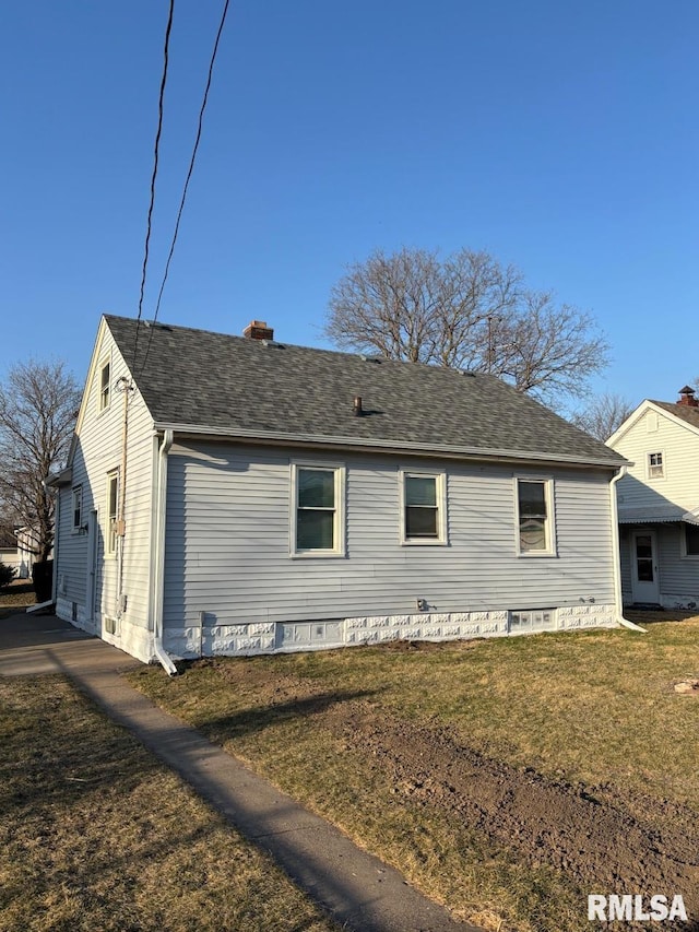 view of property exterior with a chimney, a yard, and roof with shingles