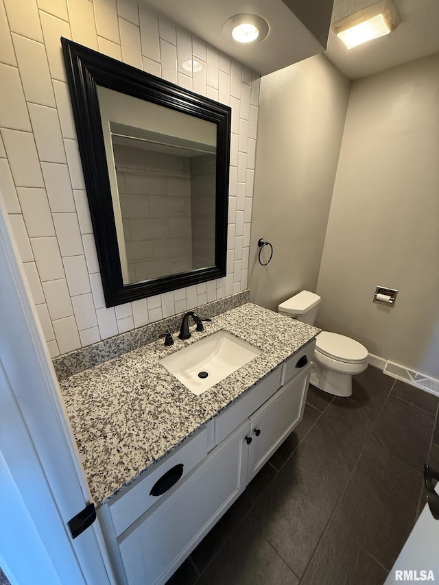 bathroom with visible vents, toilet, decorative backsplash, baseboards, and vanity