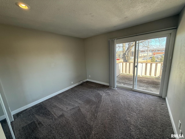 unfurnished room with a textured ceiling, baseboards, and dark colored carpet