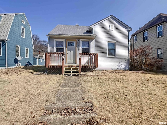 rear view of house featuring a gambrel roof, a deck, and roof with shingles