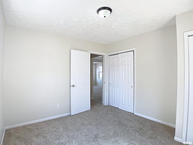 unfurnished bedroom with baseboards, carpet floors, and a textured ceiling