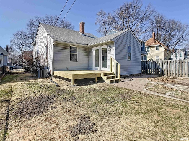 back of house with central AC, fence, a shingled roof, a wooden deck, and a chimney