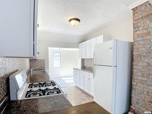 kitchen with decorative backsplash, white cabinets, white appliances, and a sink