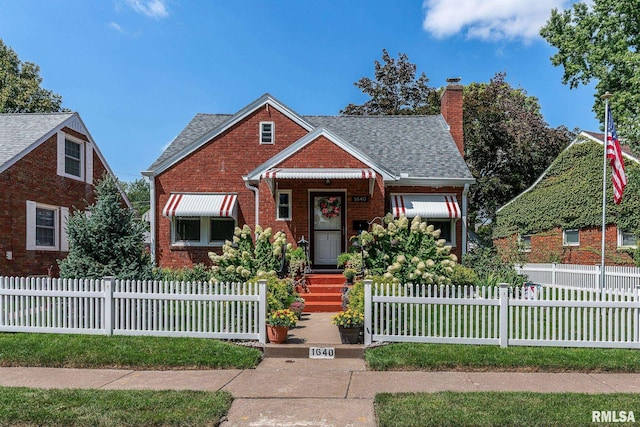 bungalow-style house featuring a fenced front yard, brick siding, roof with shingles, and a chimney