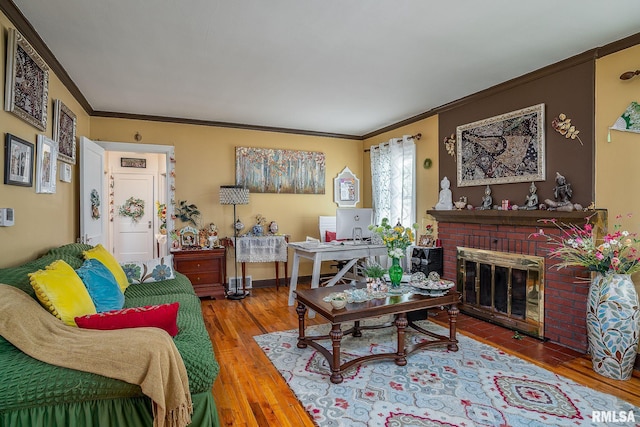 living area with a fireplace, wood finished floors, baseboards, and ornamental molding