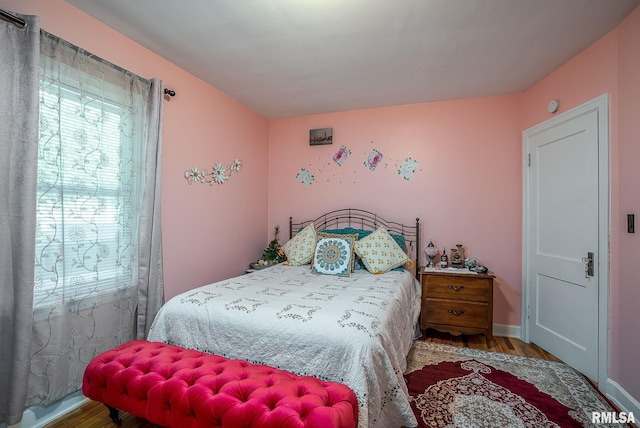 bedroom featuring baseboards and wood finished floors