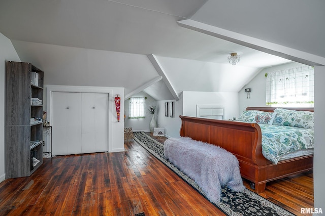 bedroom featuring dark wood finished floors, lofted ceiling, and baseboards