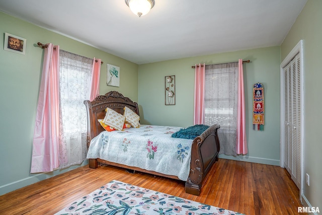 bedroom with a closet, baseboards, and wood finished floors