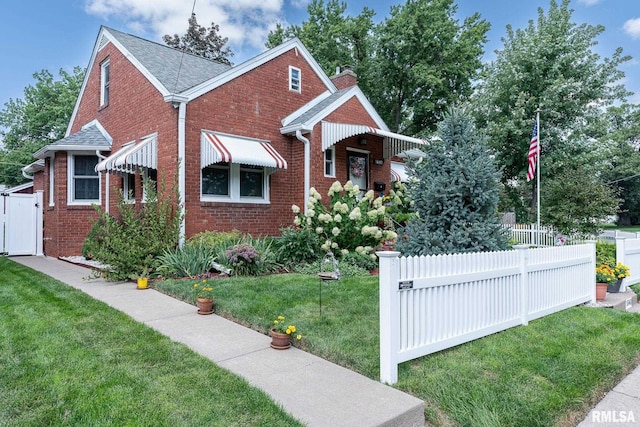 bungalow featuring a front yard, fence, and brick siding