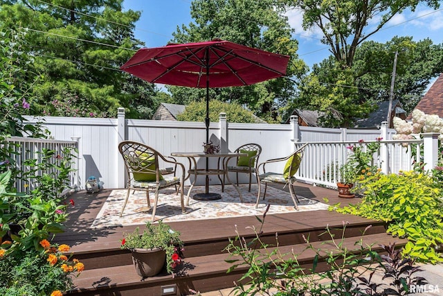 wooden deck with outdoor dining space and fence