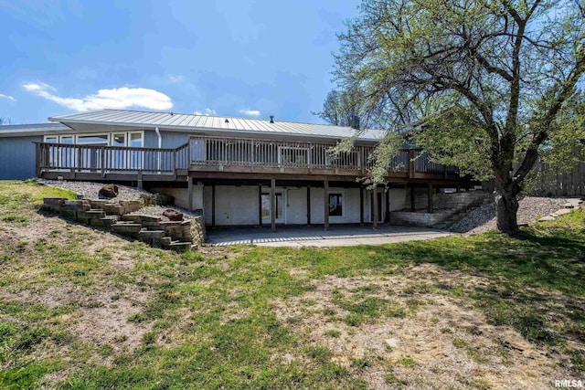 back of property featuring a patio, a yard, metal roof, and a deck