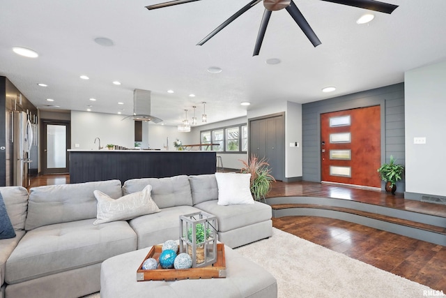 living room featuring wood finished floors, a ceiling fan, visible vents, and recessed lighting