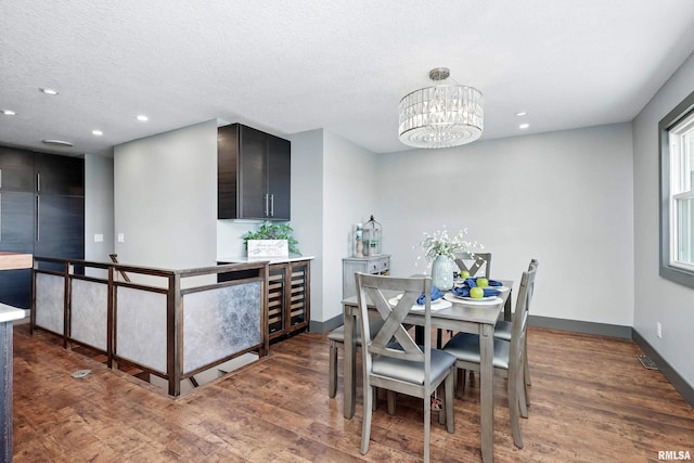 dining room featuring wood finished floors, a notable chandelier, and recessed lighting