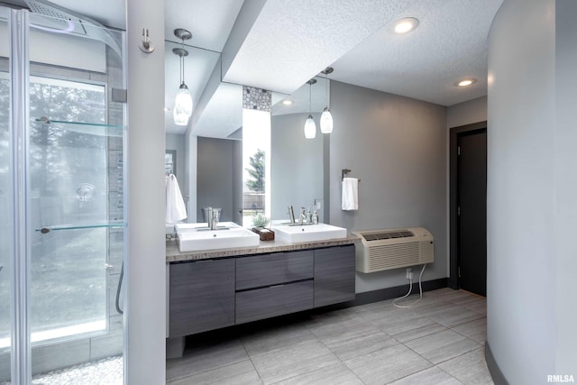 full bathroom with double vanity, a sink, a stall shower, and a healthy amount of sunlight