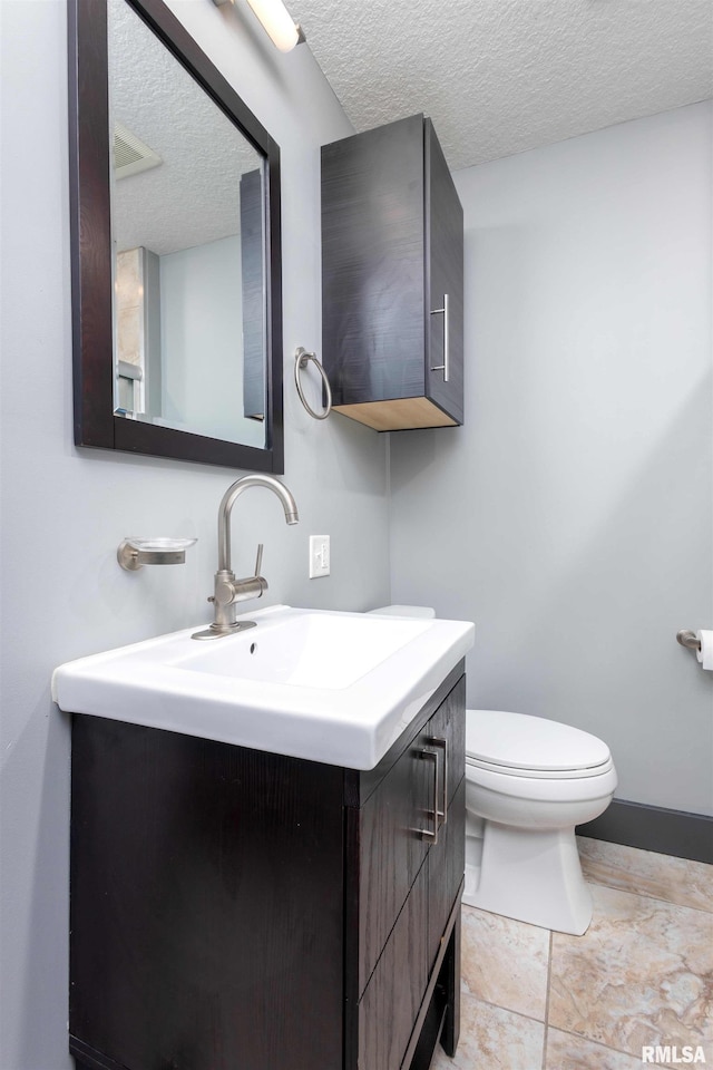 half bath featuring toilet, a textured ceiling, and vanity